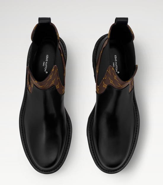 Black leather boots with brown accents on a white background