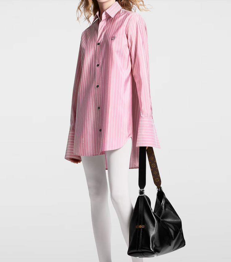Person wearing a pink striped shirt and holding a black handbag on a white background