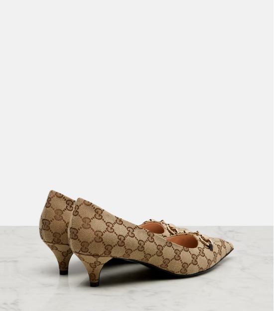 Beige gucci high-heeled shoes with a pattern on a light gray background