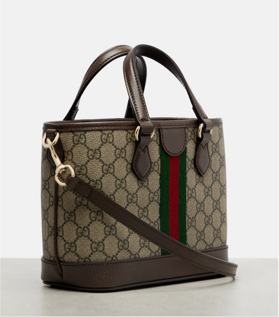 Designer handbag with GG pattern and red and green stripe on a light gray background