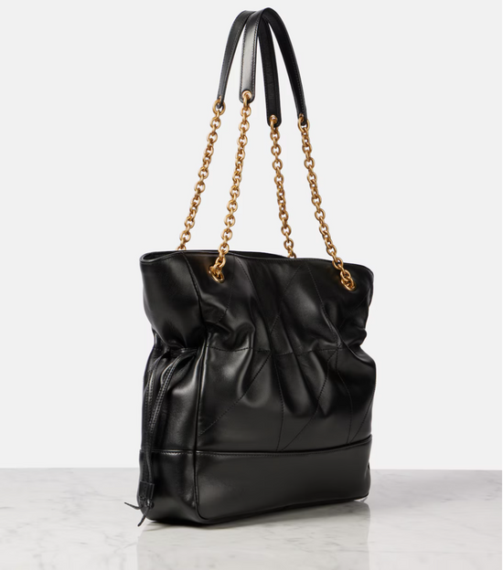 Black handbag with gold chain strap on a light gray background