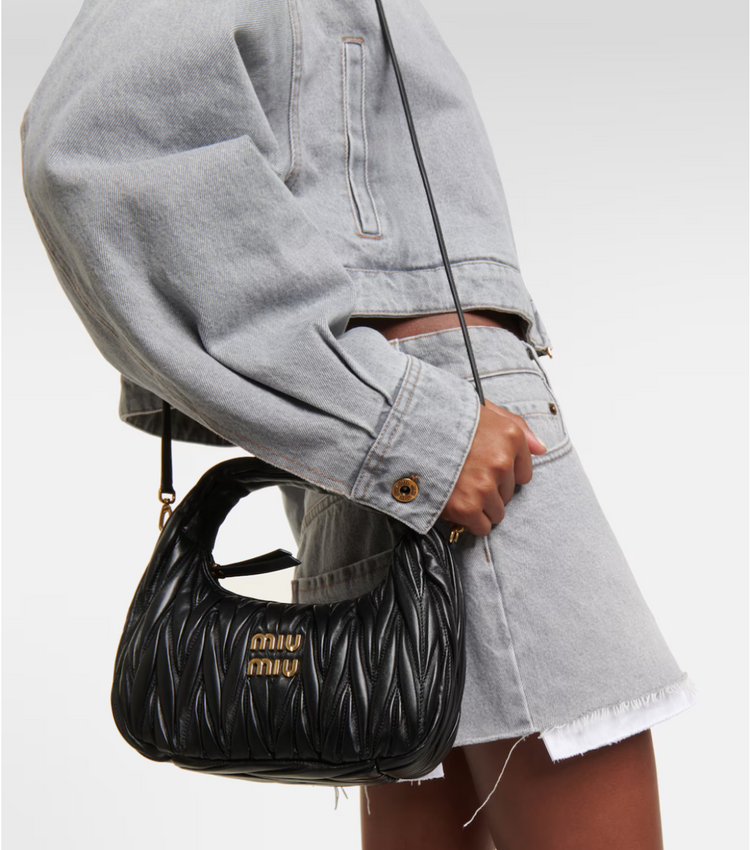 Person holding a black handbag with &