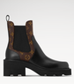 Black Chelsea boot with brown patterned side panels on a white background