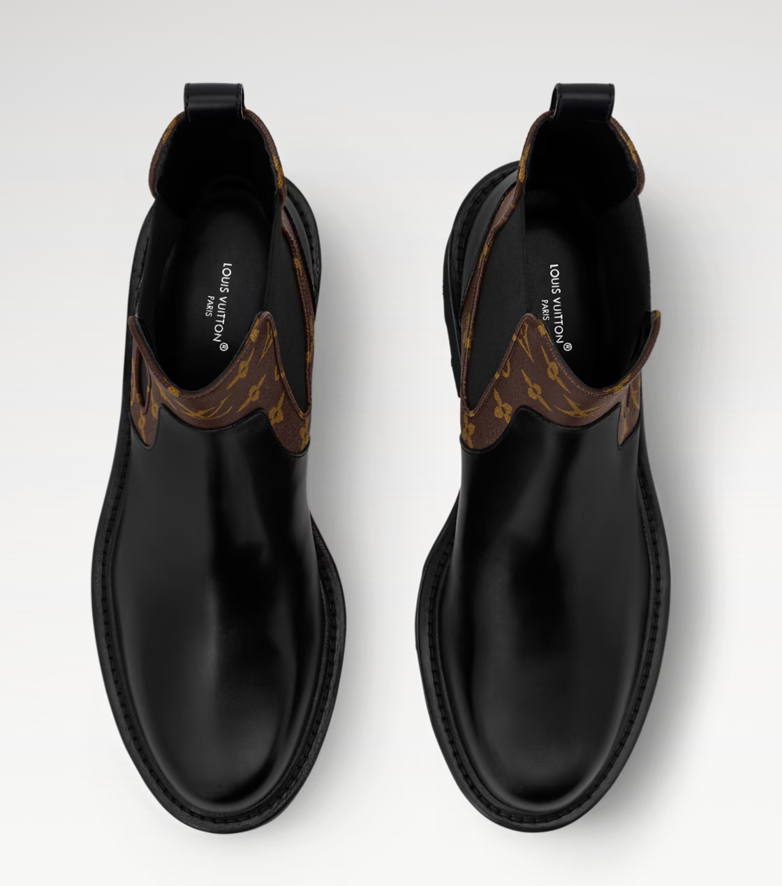 Black leather boots with brown accents on a white background