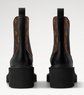 Black leather boots with brown patterned side panels on a white background