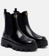 Black Chelsea boots with Prada logo on a white background