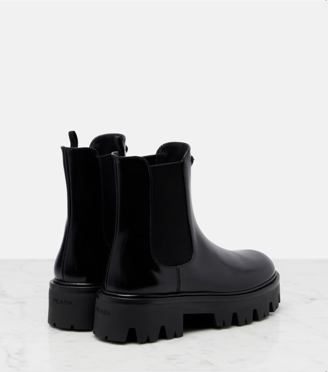 Black rubber boots with chunky sole on a light gray background
