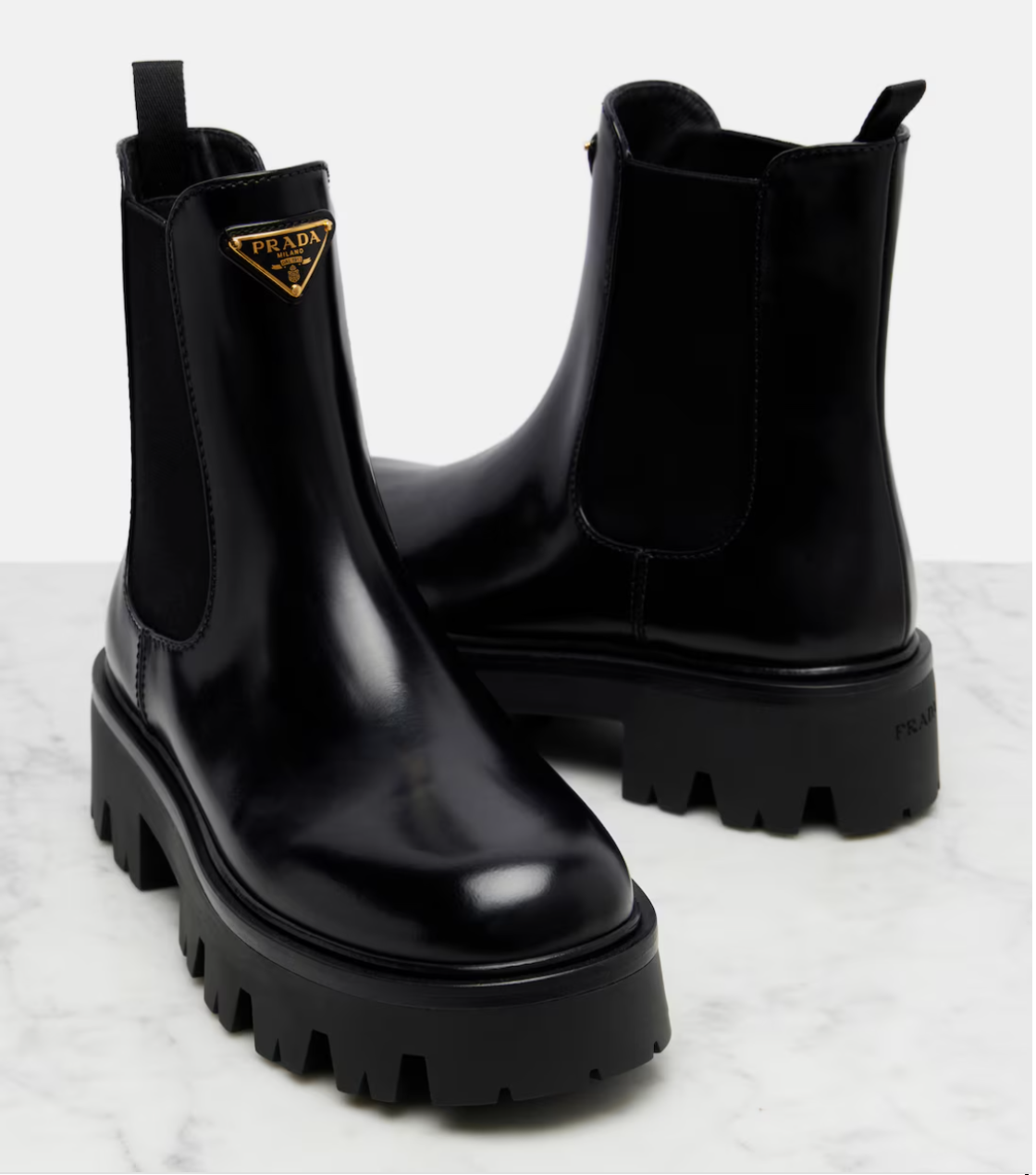 Black Prada boots on a light gray background