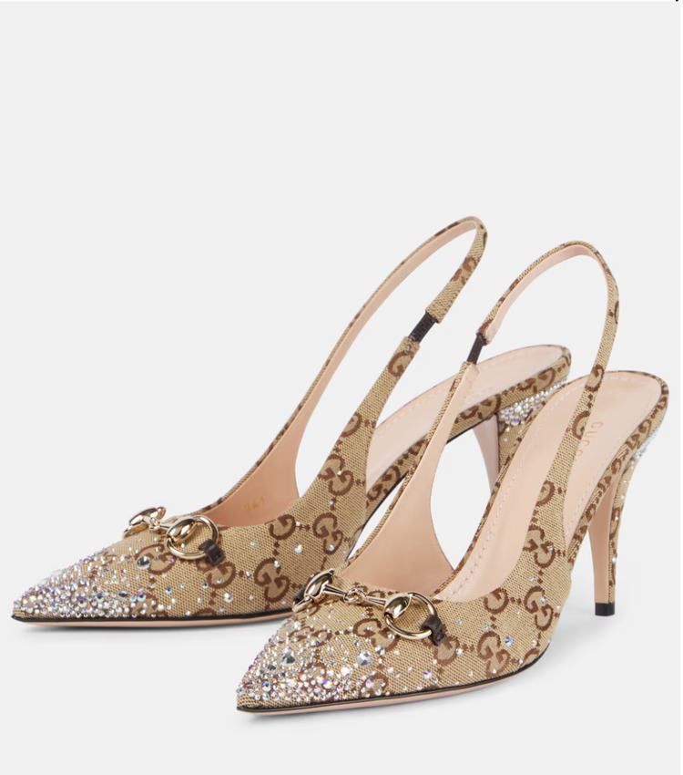 Beige high-heeled shoes with decorative elements on a white background