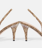 High-heeled shoes with decorative straps and embellishments on a white background