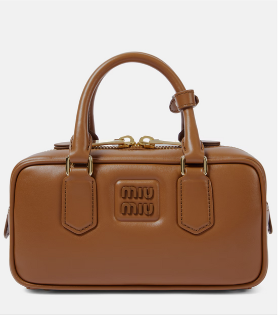 Brown leather handbag with gold accents on a white background