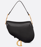 Black handbag with gold accents on a light gray background