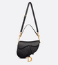Black handbag with gold accents on a light gray background