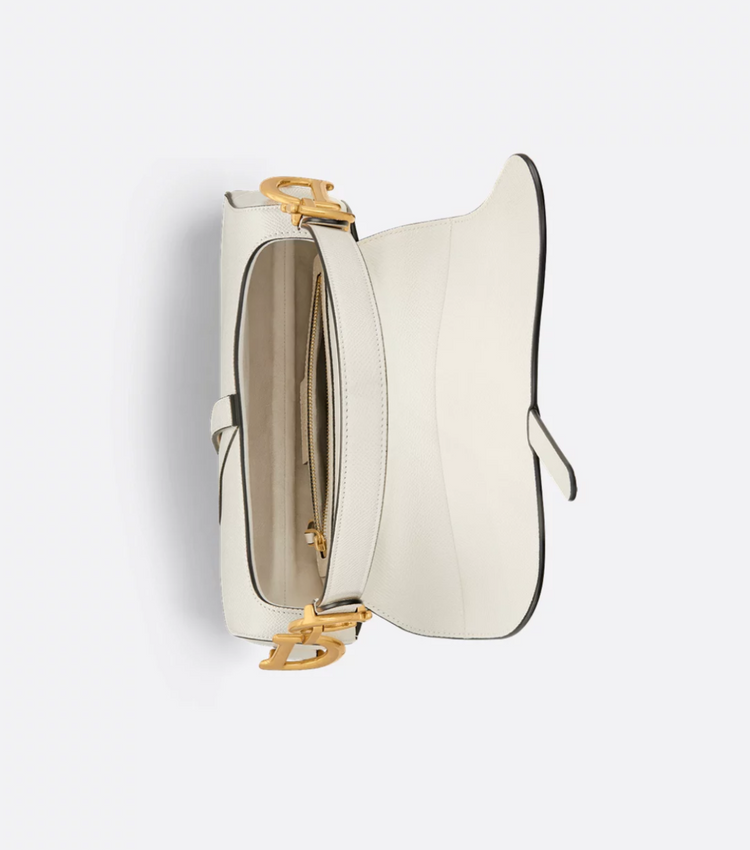 White handbag with gold accents on a light gray background