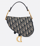 Designer handbag with monogram pattern and gold accents on a light gray background