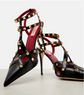 Black high-heeled shoes with gold stud details on a white background