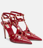 Red high-heeled shoes with gold stud details on a white background