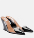 Black patent leather high-heeled shoes with clear wedge sole on a light gray background