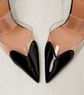 High-heeled shoes with black pointed toes and transparent heels on a light background