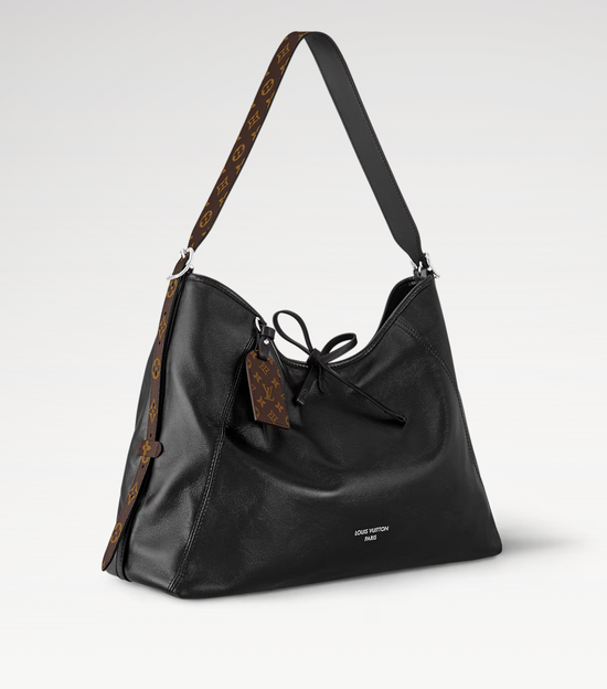 Black handbag with a patterned strap on a light gray background