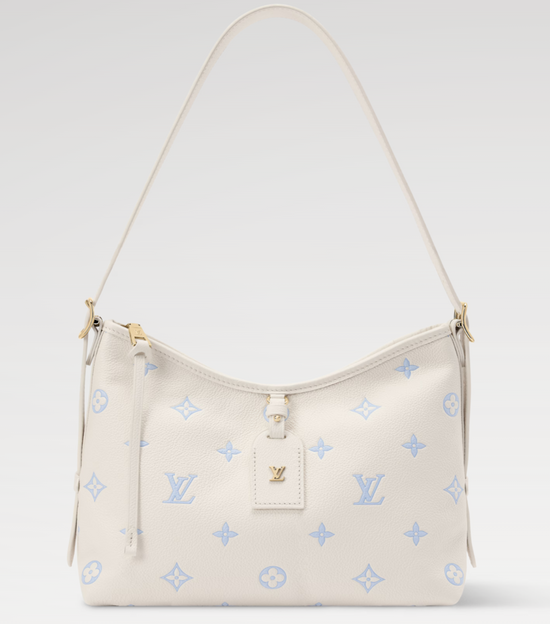 Beige handbag with blue monogram pattern on a light gray background