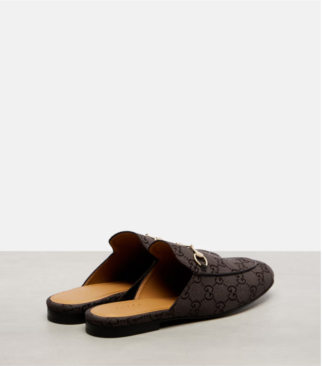 Brown Gucci loafers on a light gray background