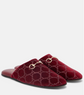 Red velvet slippers with gold chain detail on a white background