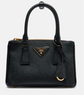 Black Prada handbag with gold accents on a white background
