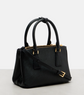 Black handbag with gold accents on a light gray background