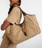 Person wearing a beige patterned outfit with a matching handbag on a white background