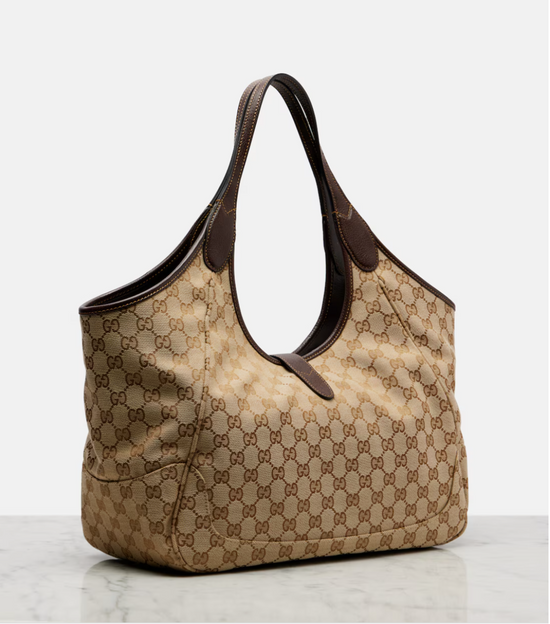 Beige gucci handbag with brown pattern on a light gray background