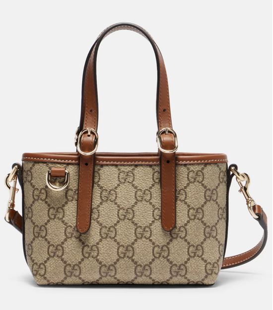 Gucci handbag with brown leather accents on a light gray background