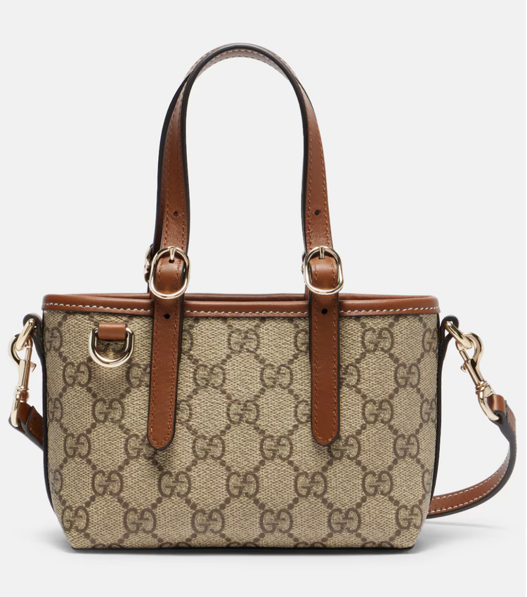 Gucci handbag with brown leather accents on a light gray background
