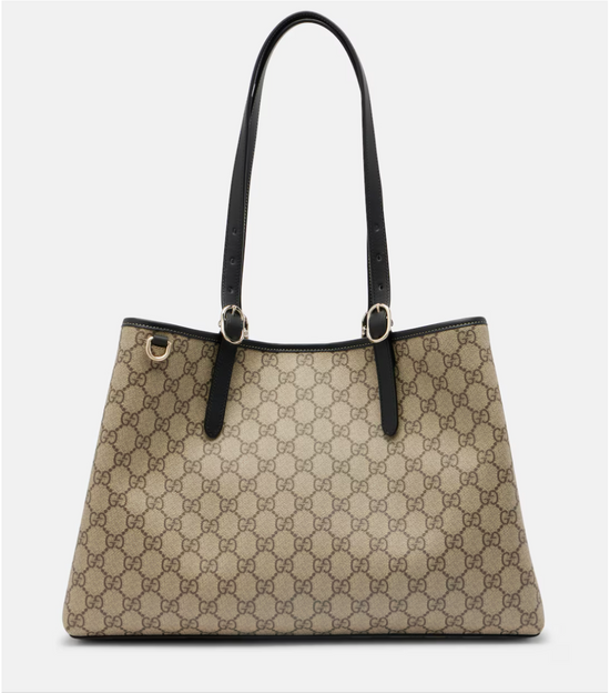 Beige gucci handbag with black handles on a light gray background