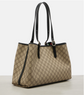 Beige gucci handbag with black accents on a light gray background