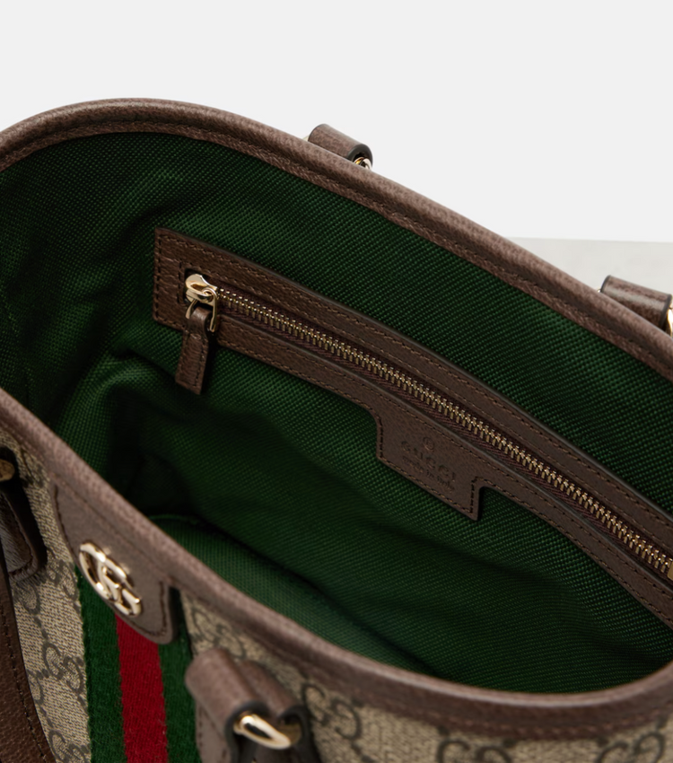 Close-up of a Gucci handbag with a green interior and visible logo.
