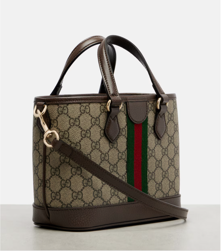 Designer handbag with GG pattern and red and green stripe on a light gray background