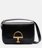 Black gucci handbag with a gold clasp on a light gray background
