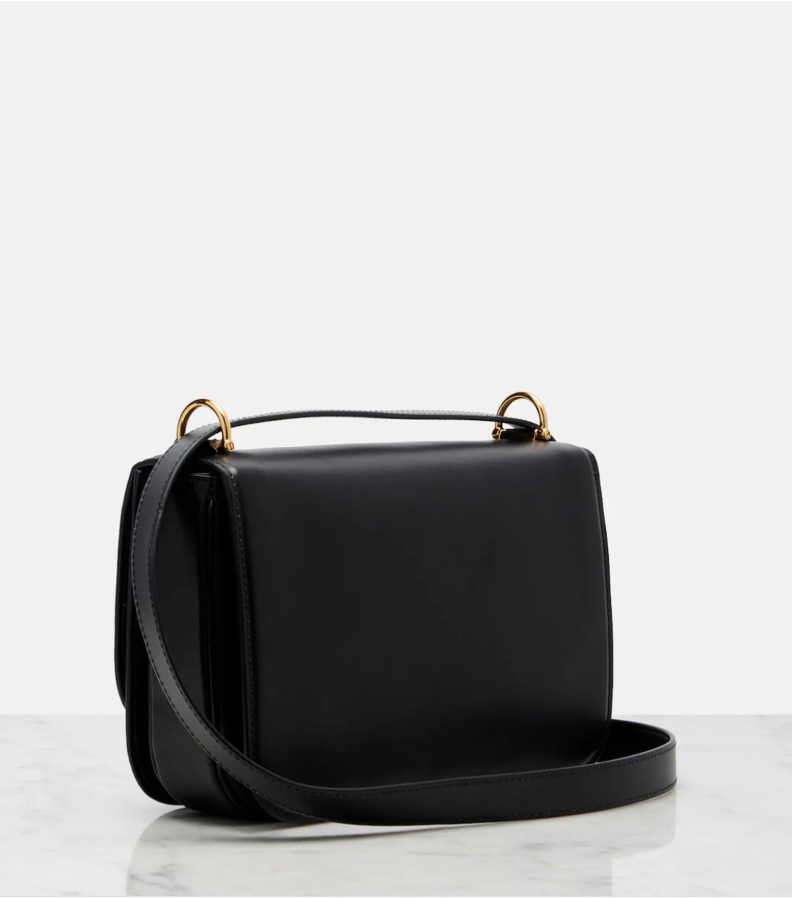 Black handbag with gold hardware on a white background
