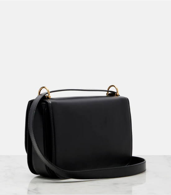 Black handbag with gold hardware on a white background