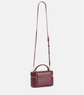 Maroon quilted handbag with a strap on a light gray background