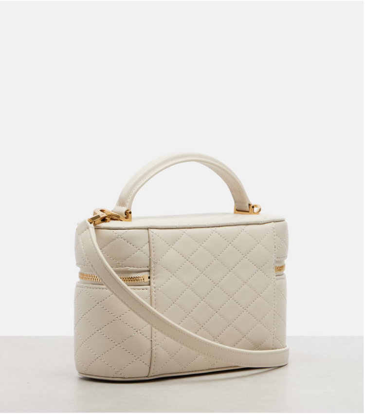 White quilted handbag with gold accents on a white background