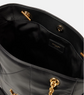 Close-up of a black handbag with gold accents on a white background