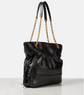 Black handbag with gold chain strap on a light gray background