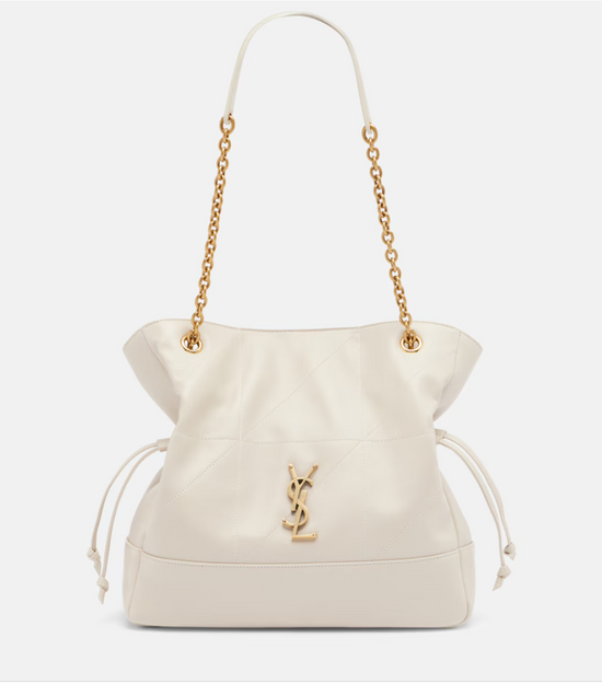 White handbag with gold chain strap and YSL logo on a light gray background