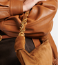 Close-up of a brown leather bag with gold chain detail