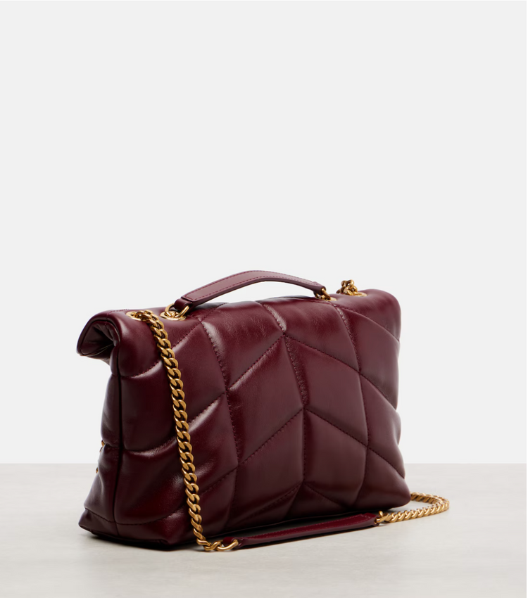 Maroon quilted handbag with gold chain on a light gray background