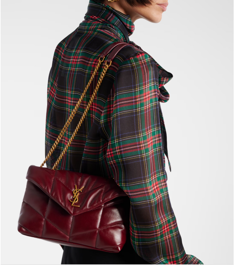 Person wearing a red plaid coat with a burgundy handbag featuring a gold chain strap.