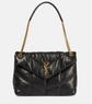 Black quilted handbag with gold chain strap on a light gray background