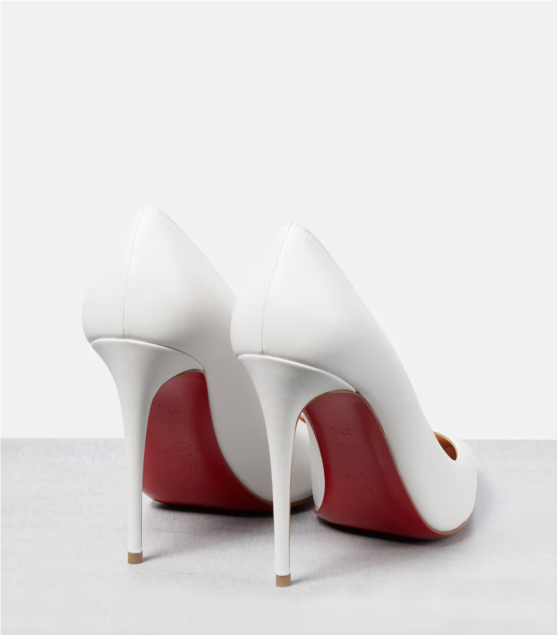 White high-heeled shoes with red soles on a white background